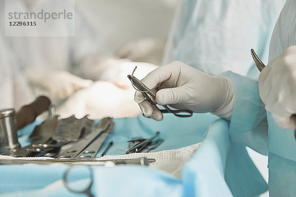Mittelteil des Chirurgen mit einer chirurgischen Schere während der Operation im Krankenhaus