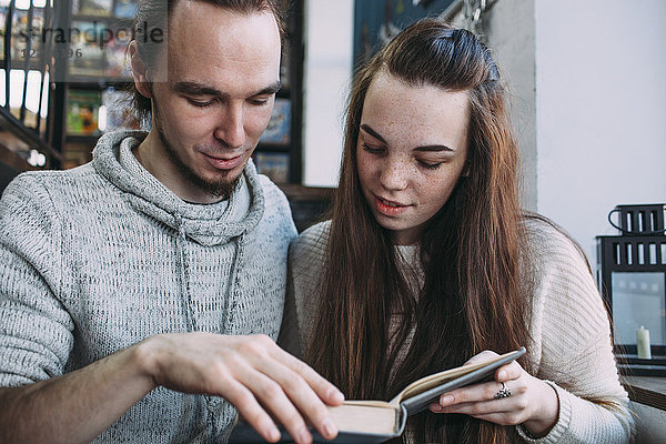 Junges Paar beim Lesen im Café