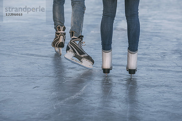 Niedriger Abschnitt des Paares Eislaufen auf der Eisbahn