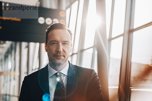 Portrait of confident businessman at airport terminal on sunny day