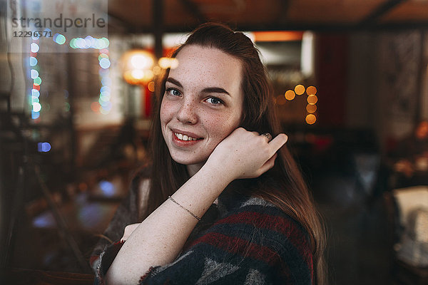 Porträt der lächelnden schönen jungen Frau im Cafe