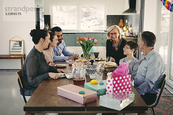 Happy multi-generation family enjoying at table during birthday party