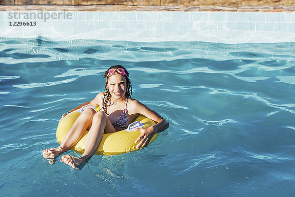 Porträt des glücklichen Mädchens im aufblasbaren Ring am Schwimmbad