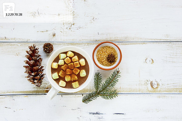 Frisch zubereitete Weihnachts- oder Neujahrs-Winterschokolade mit Marshmallows im Becher auf weißem Holzhintergrund