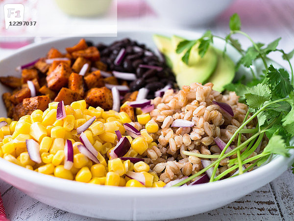 Vegane Farro-Bowl mit Mais  Süßkartoffeln  schwarzen Bohnen und Avocado