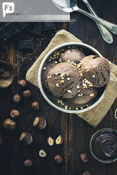 Schokoladen- und Haselnusseis in einer silbernen Schale mit gehackten Nüssen