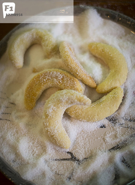 Gebackene Vanillekipferl  die in Zucker gewälzt werden