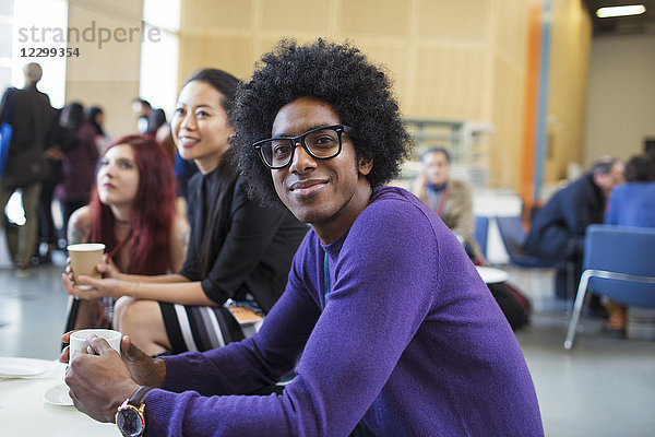 Portrait smiling  confident businessman drinking coffee at conference