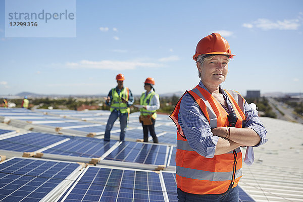 Portrait confident female engineer at sunny solar power plant