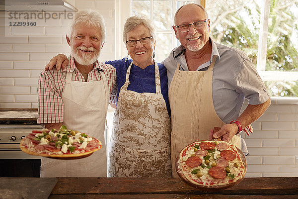 Portrait smiling  confident senior friends making pizza in cooking class