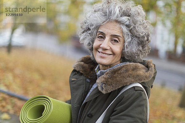 Portrait smiling  confident active senior woman with yoga mat