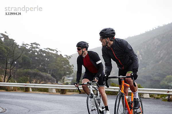 Male cyclists cycling on road