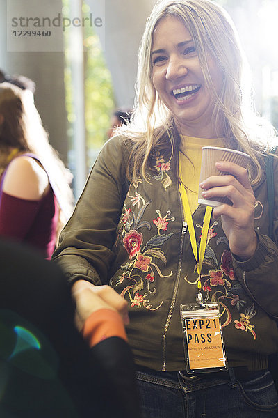 Smiling woman with coffee at conference