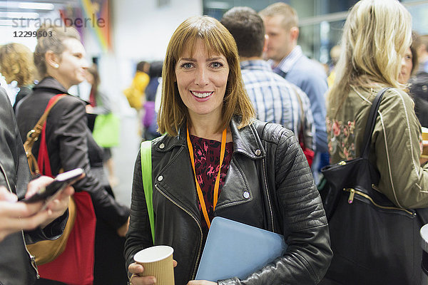 Portrait smiling  confident businesswoman drinking coffee at conference