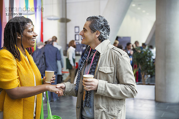 Businessman and businesswoman networking  handshaking at conference