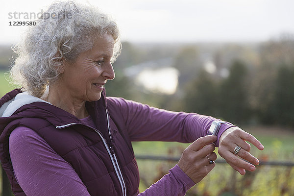 Active senior woman exercising  using fitness tracker smart watch