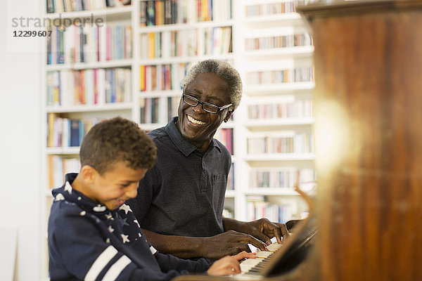 Happy grandfather and grandson playing piano