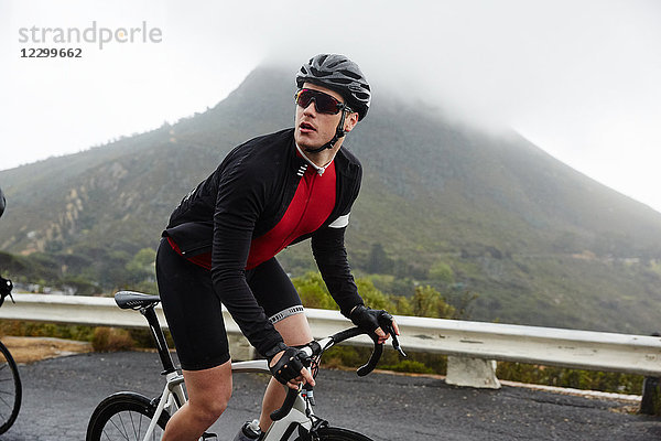 Male cyclist cycling mountain road