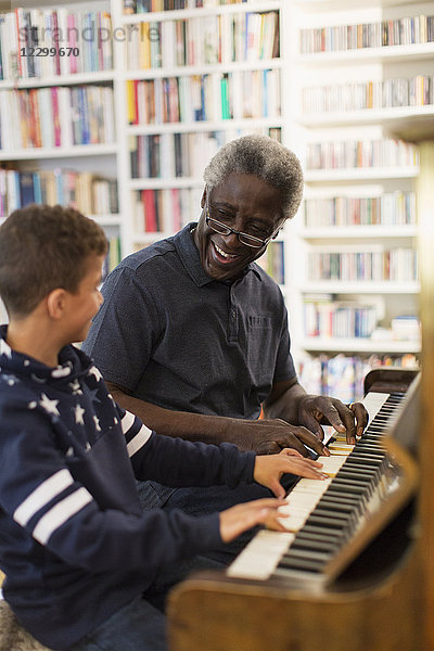 Grandfather and grandson playing piano