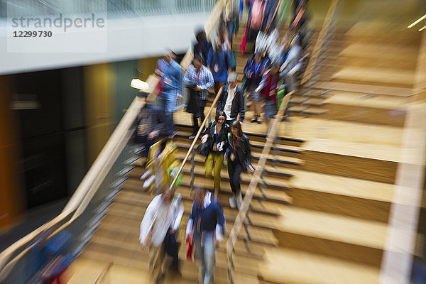 Blurred motion people descending wooden stairs