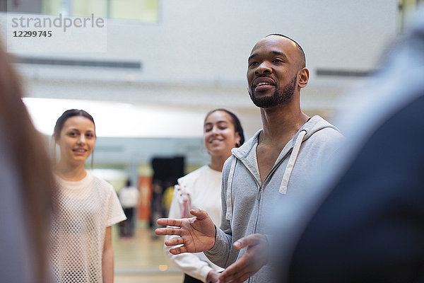 Male instructor leading discussion in dance class studio