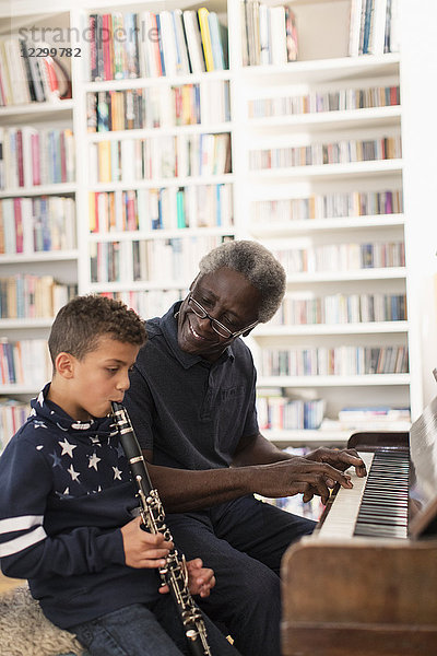 Grandfather and grandson playing piano and clarinet