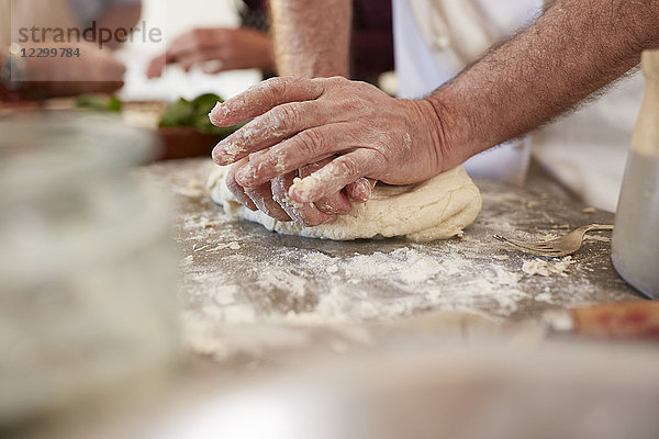 Close up man kneading pizza dough