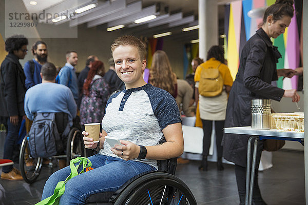 Portrait smiling  confident woman in wheelchair using smart phone at conference