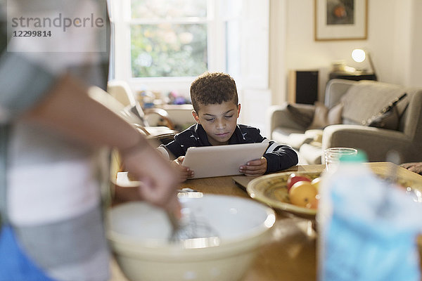 Curious boy using digital tablet in kitchen