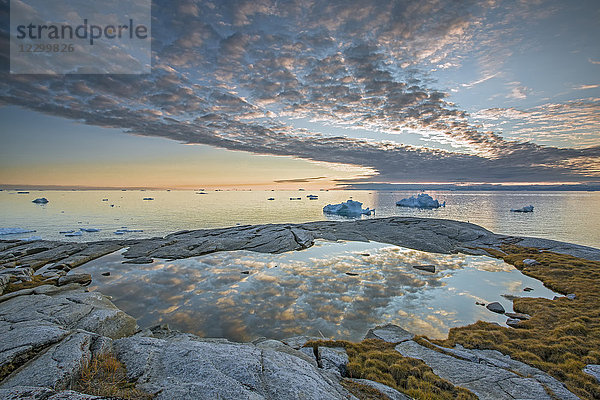 Idyllic clouds over remote ocean with icebergs  Kalaallisut  Greenland