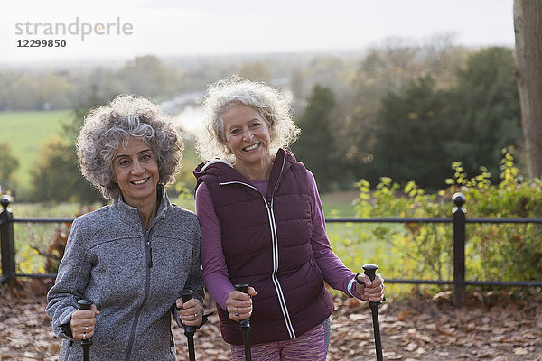Portrait smiling  confident active senior women friends hiking with poles