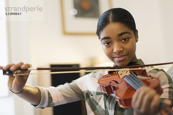 Portrait confident teenage girl playing violin