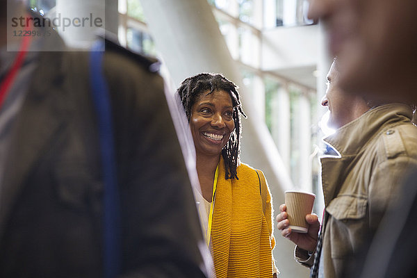 Smiling businesswoman networking  talking to colleague at conference