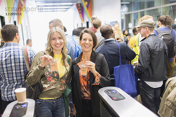 Portrait smiling  confident women showing lanyard conference passes