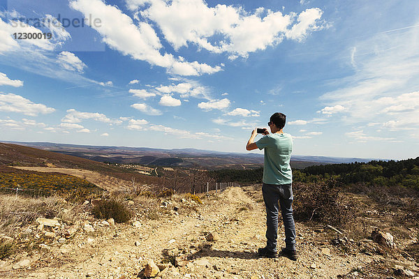 Teenager fotografiert die Landschaft des Montesinho-Naturparks mit seinem Smartphone  Portugal