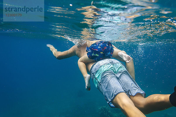 Vater und Sohn tauchen unter Wasser  Bali  Indonesien