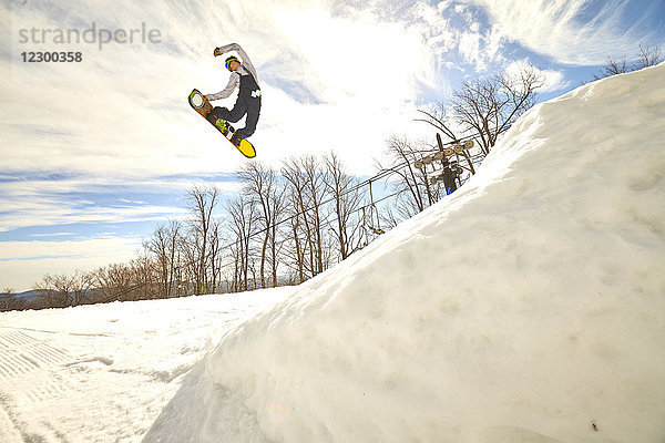 Snowboarder beim Switch-Methode-Trick in der Luft  Vermont  USA
