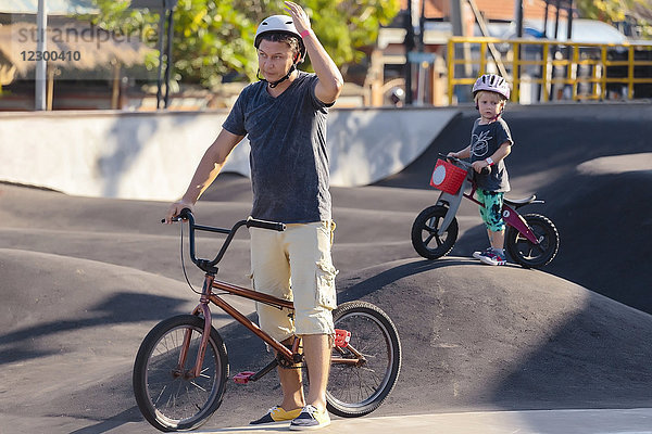 Vater mit Sohn mit BMX-Rädern im Skatepark