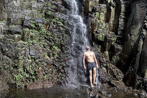 Mann in voller Länge unter Wasserfall stehend  La Gomera  Kanarische Inseln  Spanien