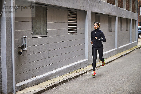 Frau joggt durch eine städtische Gasse  Boston  Massachusetts  USA