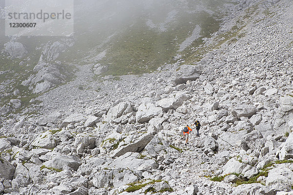 Zwei Wanderer wandern im felsigen Gelände des Berges Krn in den südwestlichen Julischen Alpen  Slowenien