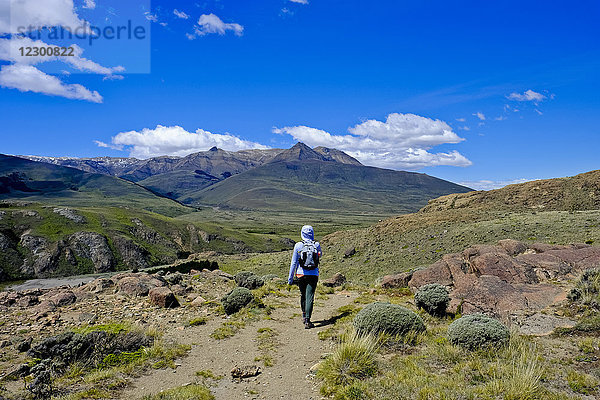 Rückansicht einer weiblichen Rucksacktouristin in einer Berglandschaft  El Chalten  Provinz Santa Cruz  Patagonien  Argentinien