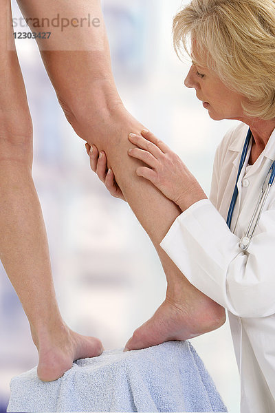 Ein Arzt untersucht das Bein eines Patienten.