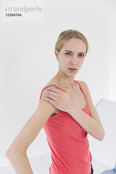 Weibliche Patientin  die wegen Schulterschmerzen konsultiert wird.
