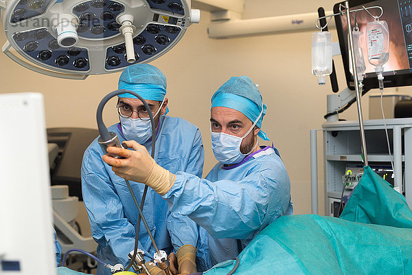 Reportage über eine Nierentransplantation in der urologischen Abteilung des Krankenhauses von Nizza  Frankreich. Die Niere wird von einem lebenden verwandten Spender  der Frau des Empfängers  entnommen. Entnahme der Spenderniere mit dem da Vinci-Roboter. Der Chirurg und der Assistenzarzt richten die Trokare ein.