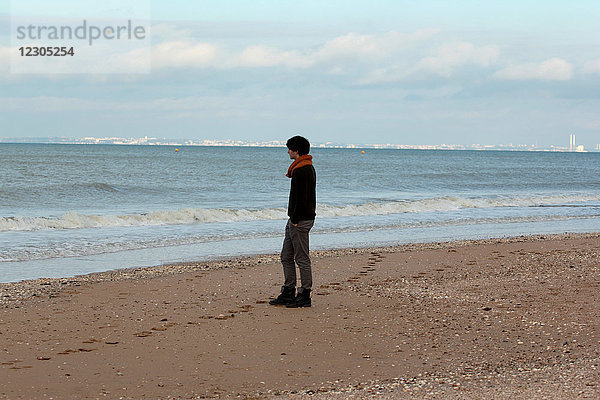 Mann spaziert am Strand.