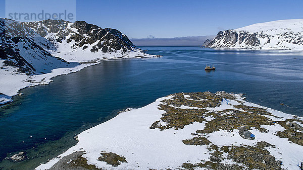 Luftaufnahme des Arktischen Ozeans mit Küstenlinie und Fischerboot im Hintergrund  Danskoya  Spitzbergen  Svalbard und Jan Mayen  Norwegen
