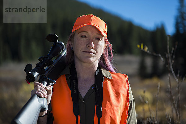 Porträt einer Jägerin in Pose mit Gewehr über der Schulter  Colorado  USA