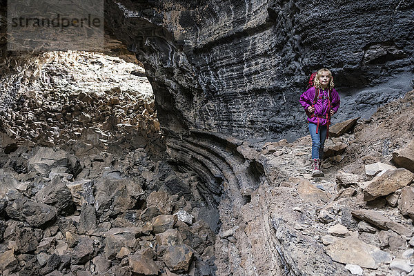 Kleines blondes Mädchen beim Höhlenforschen in der Lavaröhre des El Malpias National Monument  Grants  New Mexico  USA