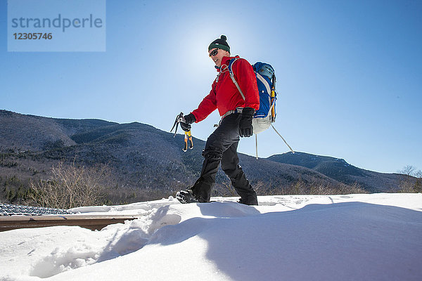 Eiskletterer  der an einem warmen Wintertag zum Eisklettern in die Frankenstein-Felsen steigt  Crawford Notch  New Hampshire  USA